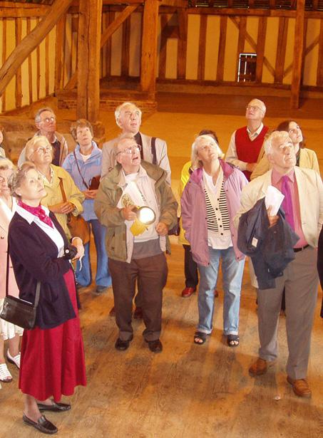 Adrian Gibson (centre with torch) talking about Cressing Temple Barns on a Trust outing in 2005. To the far left of the photograph Dorothy Abel Smith, to the far right Russ Craig  - About the Trust -  Hertfordshire Building Preservation Trust